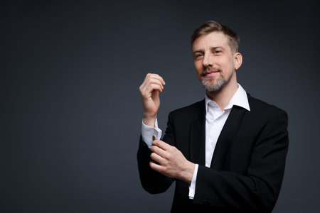 Handsome man in suit on grey background. Space for text