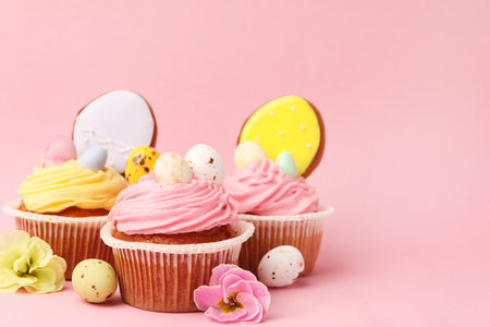 Tasty cupcakes with Easter decor on pink background, closeup. Space for textの写真素材