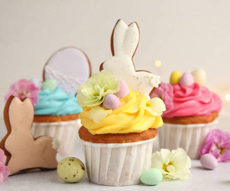 Tasty cupcakes with Easter decor on light grey table, closeup