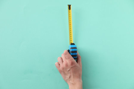 Woman with measuring tape on turquoise background, top viewの写真素材