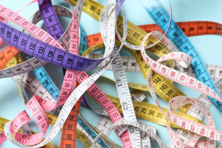 Different measuring tapes on light blue background, above viewの写真素材