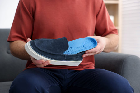 Man putting insole into shoe indoors, closeupの写真素材