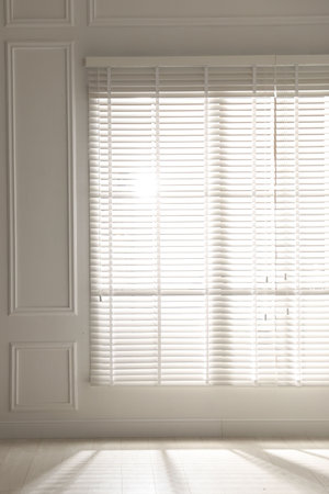 Sun shining through window blinds in light room