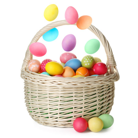 Easter eggs falling into basket on white background