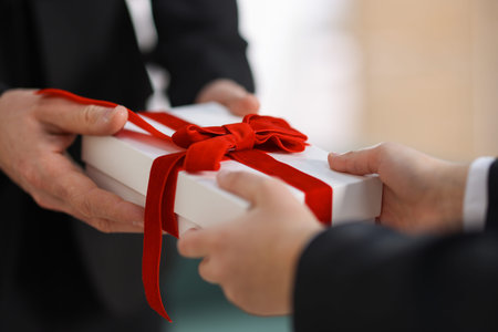Boy greeting his father with gift indoors, closeupの写真素材