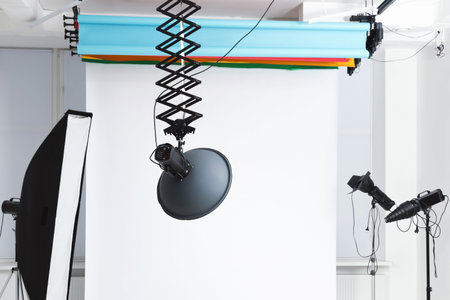 Professional lighting equipment hanging from ceiling in photo studio