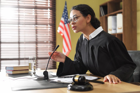 Judge working at wooden desk in courtroomの写真素材