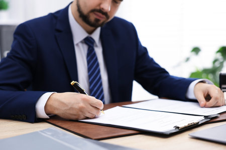 Notary working at wooden desk in office, closeup