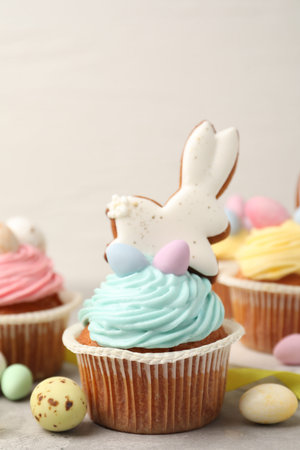 Tasty cupcakes with Easter decor on grey table, closeup
