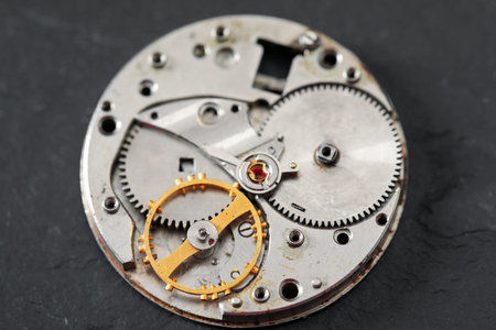 Mechanism of vintage wrist watch on black table, above view
