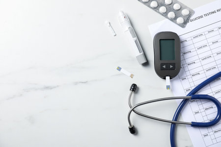 Diabetes. Flat lay composition with digital glucometer and lancet pen on white marble table, space for textの写真素材