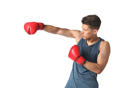 Athletic man in red boxing gloves fighting on white background