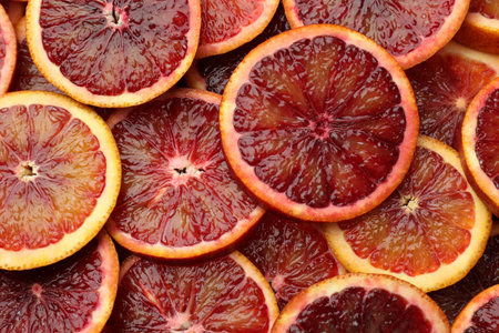 Slices of ripe Sicilian oranges as background, top view
