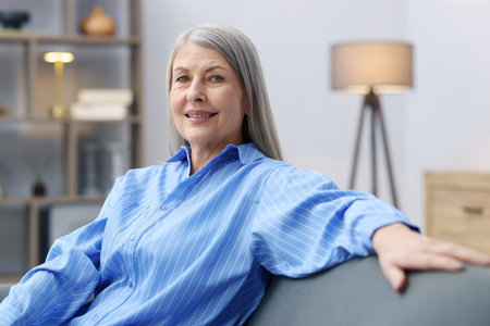 Portrait of smiling senior woman on sofa at home