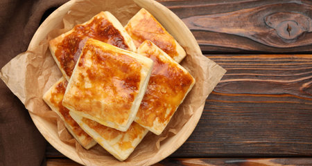 Tasty puff pastries on wooden table, top view. Space for text