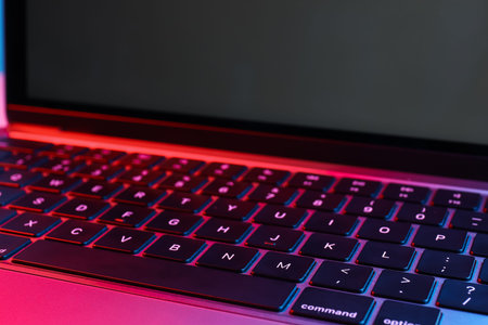 Stylish modern laptop in neon lights, closeup