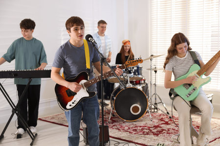 Teenage music band practicing their performance indoorsの写真素材