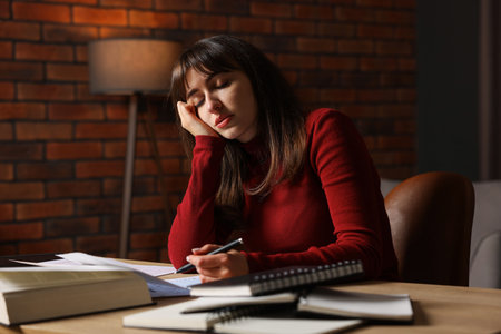 Woman feeling fatigue at wooden desk indoors