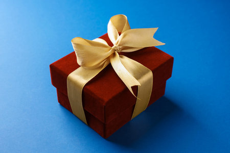 Beautiful velvet gift box on blue background, closeup