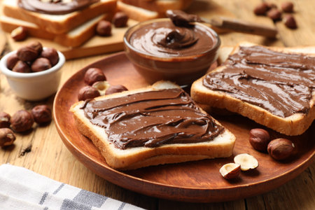 Toasts with chocolate paste and hazelnuts on wooden table, closeupの写真素材
