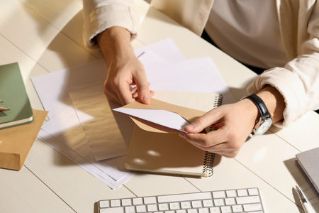 Man opening envelope with letter at wooden table indoors, above view