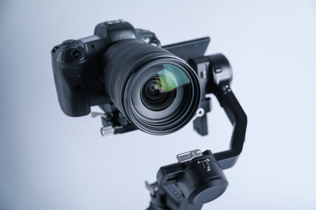 Gimbal stabilizer with camera on light background, closeup