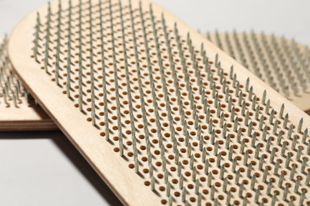 Nail standing practice. Sadhu boards on light background, closeup
