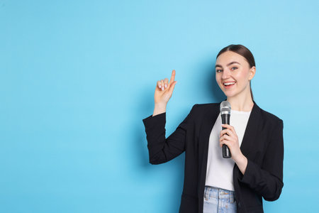 Happy news presenter with microphone on light blue background, space for text