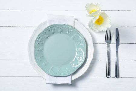 Stylish table setting with floral decor on white wooden background, flat lay