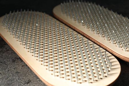 Nail standing practice. Sadhu boards on gray textured background, closeup