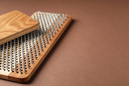 Standing on nails. Two Sadhu boards on brown background, closeup. Space for text
