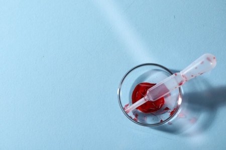 Petri dish and pipette with liquid samples on light background, top view. Space for text