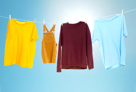 Clothes drying on laundry line outdoors against blue sky