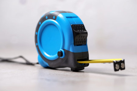 One measuring tape on grey table, closeup