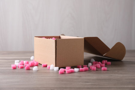 Cardboard box with styrofoam pieces on wooden table