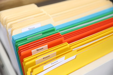 Tax. Many folders in drawer of cabinet in office, closeup