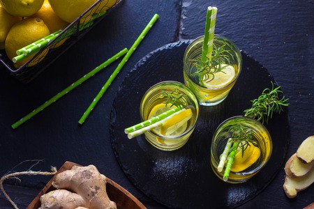 Ingredients for making flu fighting natural hot drink. Oranges, mint, lemons, ginger, honey, apple and spices over plywood background, top view, copy space. Clean eating, detox, dieting conceptの写真素材
