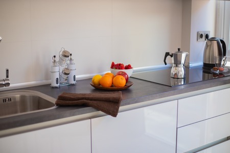 White contemporary kitchen with stone floor and black accessories