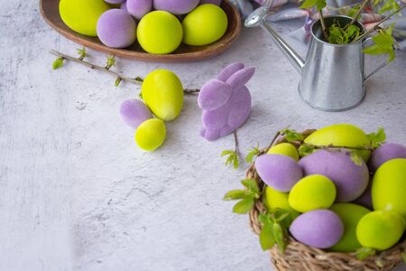 easter green and purple eggs with rabbit on a light surface