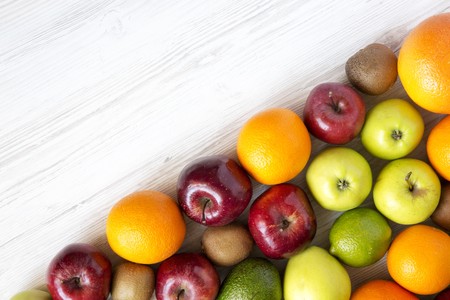 Set of fresh raw fruits on white wooden background. Top view. Flat lay. Summer background. Copy space.の写真素材