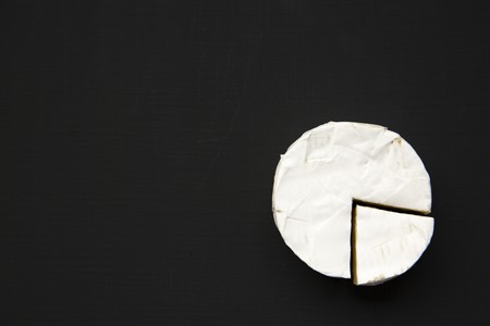 Cheese camembert or brie on dark background. Milk production. Top view. Flat lay. Copy space.の写真素材
