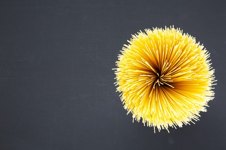 Spaghetti on dark background with copy space. Long spaghetti. Raw spaghetti. Top view. From above. の写真素材
