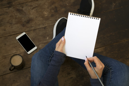 Woman writes in a notebook, top viewの写真素材