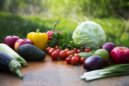 Set of organic vegetables and fruits on rustic wooden table and blur background. Side view.の写真素材