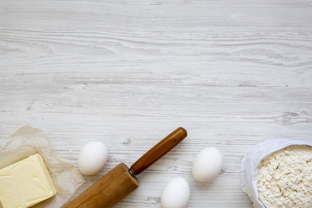 Ingredients for dough preparation on white wooden background, from above. Copy space. Flat lay. Top...