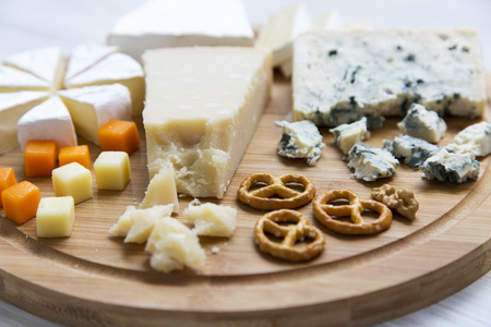 Delicious cheeses: camembert, blue cheese, brie, parmesan, mimolette and edam with pretzels and...