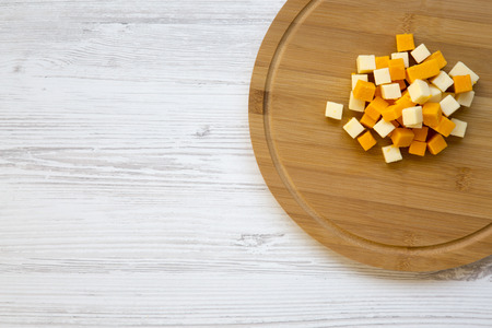 Pieces of mimolette and edam cheeses on wooden board. Top view. Copy space.の写真素材