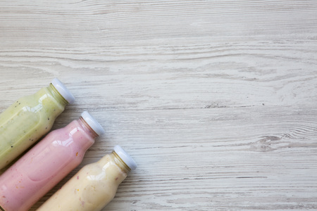 Top view, fruit smoothies of different tastes in glass jars on white wooden background. From above. Copy space. の写真素材