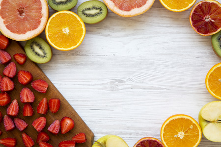Frame of fresh ripe fruits on white wooden table, top view. Text area. From above, flat lay.