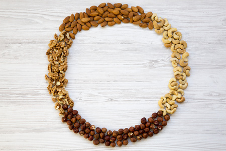 Assortment of nuts on white wooden background. Cashew, hazelnuts, walnuts, almonds. Top view, flat...